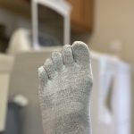 Gray toe sock in a laundry room