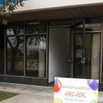 Entrance with arcade sign and glass doors.