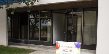 Entrance with arcade sign and glass doors.