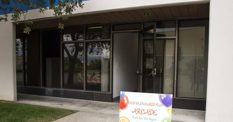 Entrance with arcade sign and glass doors.