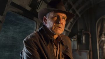 Man in hat and leather jacket indoors