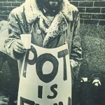 Man holding sign that says 'Pot is Fun'.