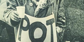 Man holding sign that says 'Pot is Fun'.