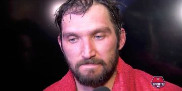 Athlete in red towel during interview.