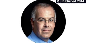 Man in glasses with gray hair and blue shirt