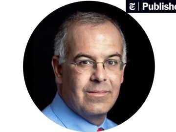 Man in glasses with gray hair and blue shirt