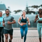 Group jogging outdoors, smiling and fit.