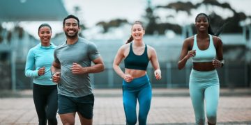 Group jogging outdoors, smiling and fit.