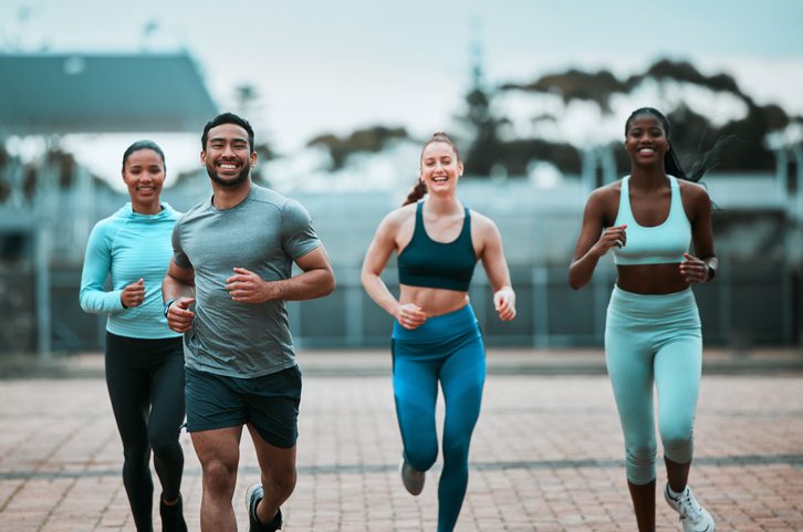 Group jogging outdoors, smiling and fit.