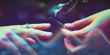 Hands passing a smoking joint, colorful background.