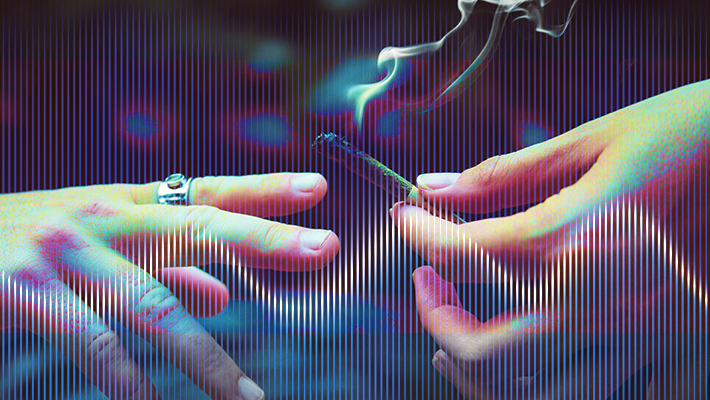 Hands passing a smoking joint, colorful background.