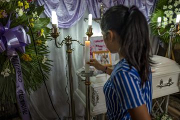 Woman lighting candle at a memorial service.