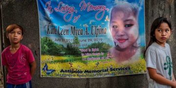 Memorial banner with two children nearby.