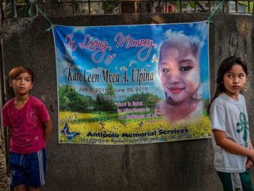 Memorial banner with two children nearby.