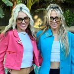 Two women smiling by a poolside.