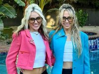 Two women smiling by a poolside.