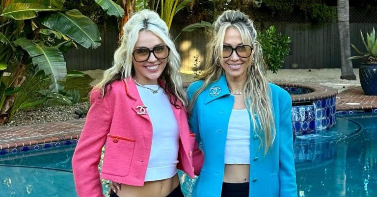 Two women smiling by a poolside.