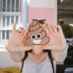 Person holding smiling poop emoji cookie