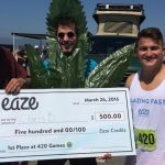 Three people holding large check at 420 Games.